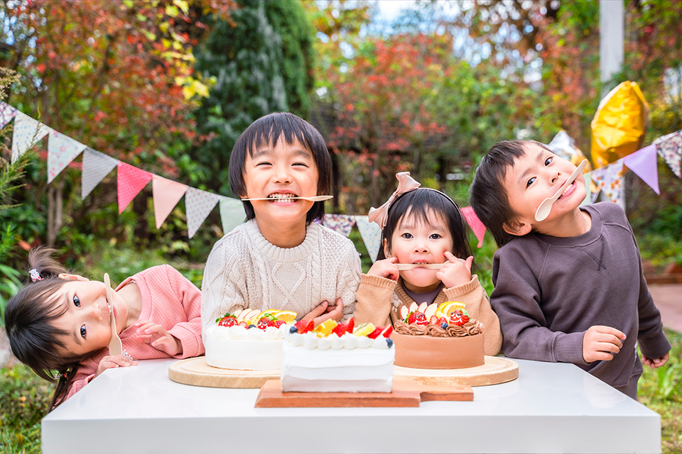 ケーキを囲む笑顔の子供たちの写真